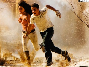 Shia Lebouf e Megan Fox correndo na frente com Transformes 2